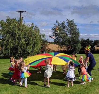 children in garden with the parachute