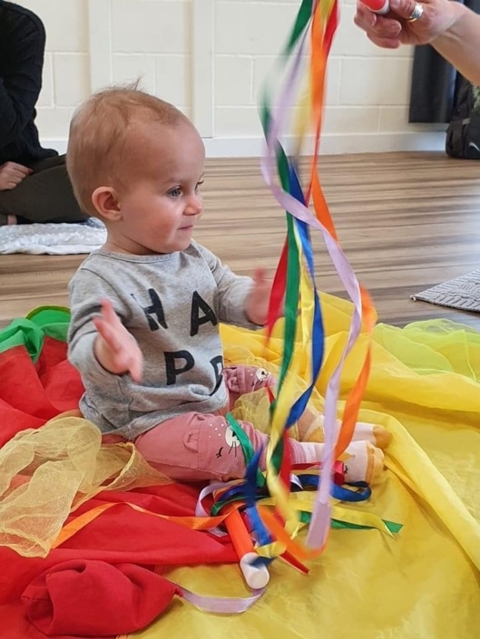 Baby watching rainbow baton