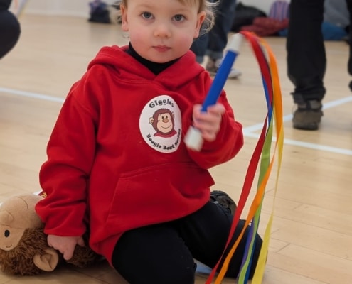 Girl in boogie beat hoodie with rainbow wand