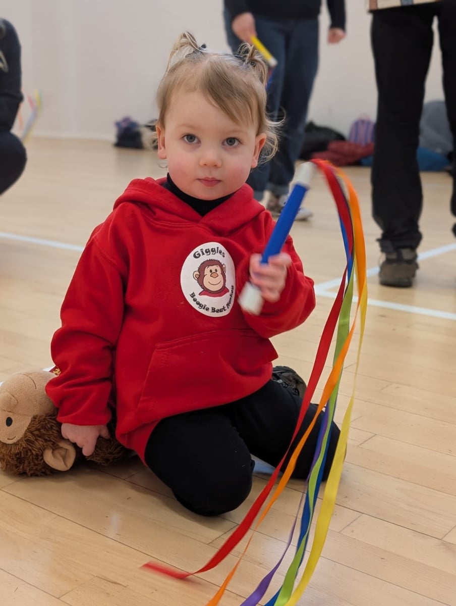 Girl in boogie beat hoodie with rainbow wand