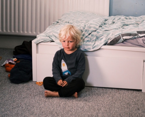 Picture of a child sat next to bed