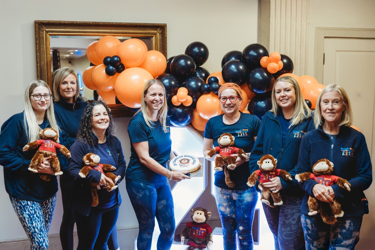 group of ladies holding a cake