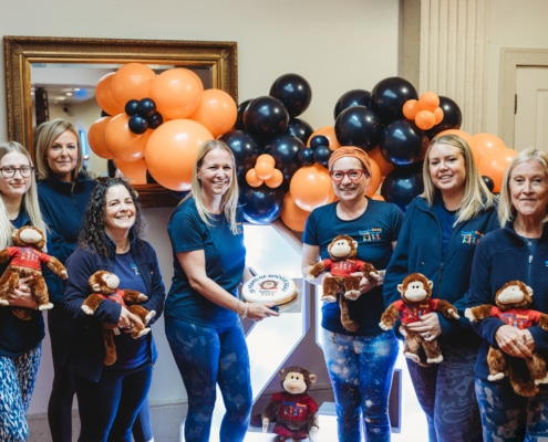 group of ladies holding a cake
